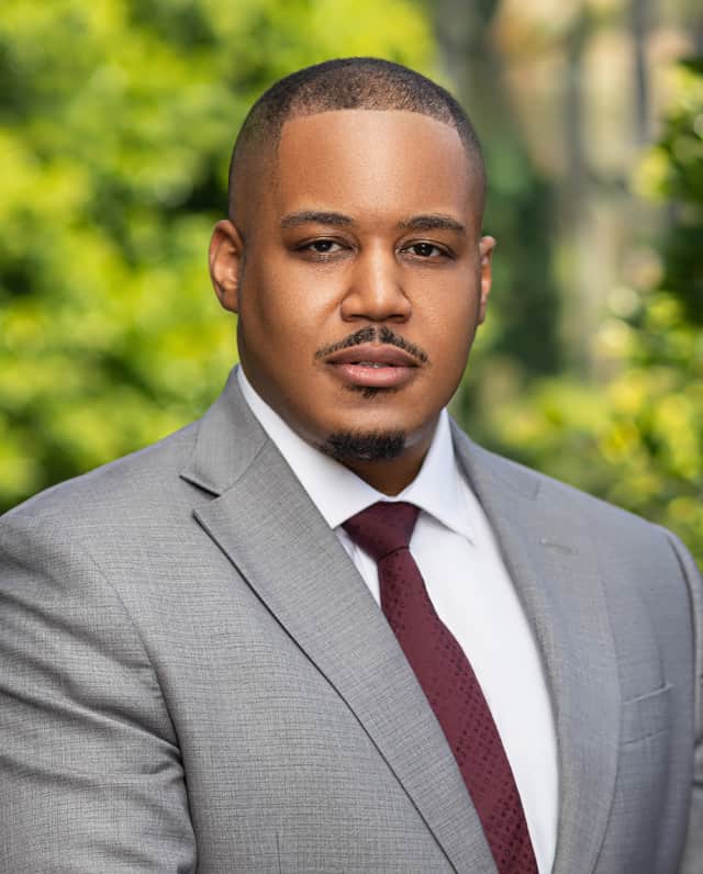 headshot of Ian Hartsfield with a green background